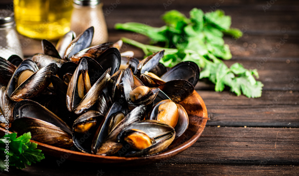 Boiled mussels in a plate with parsley. Boiled mussels in a plate with parsley.