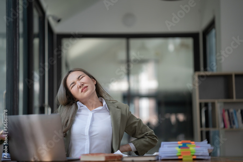Portrait of Asian businesswoman with shoulder pain and backache office background, Female working hard, office syndrome concept.