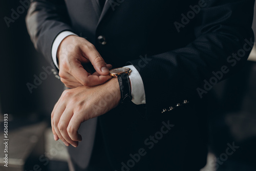 businessman checking time on his wrist watch, man putting clock on hand,groom getting ready in the morning before wedding ceremony