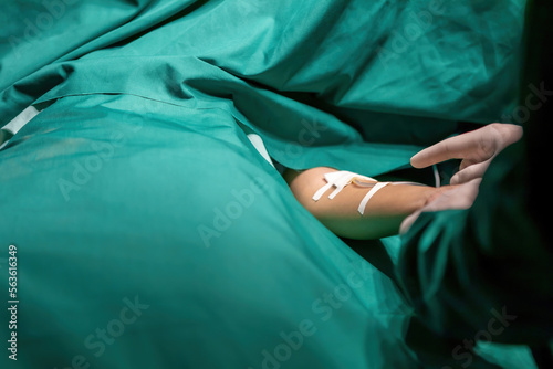 doctor putting medical tape tube patient for infusion operation. expert surgeon performing stick tape to attach tube. professional surgery staff attach iv bag cord to person arm with adhesive tape