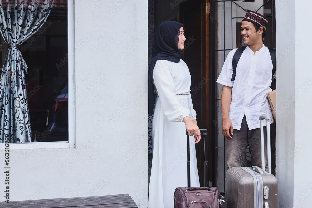Young muslim couple carrying suitcases ready to mudik to their hometown in Eid Mubarak moment. Young muslim couple carrying suitcases ready to mudik to their hometown in Eid Mubarak moment.