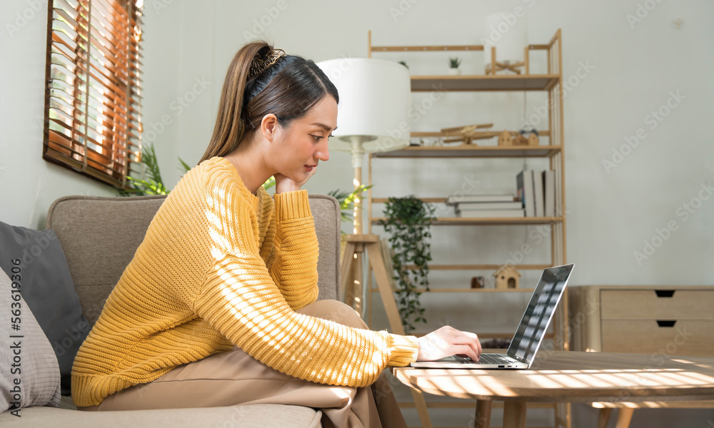 © wichayada - Portrait of a young happy female sitting on the couch and working on project, watching movie on laptop, studying, blogging, resting and chatting online. © wichayada - Portrait of a young happy female sitting on the couch and working on project, watching movie on laptop, studying, blogging, resting and chatting online.