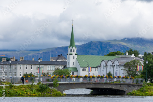 Reykjavik, Iceland - July 29, 2022: Frikirkja with bridge in the foreground and mountains in the background