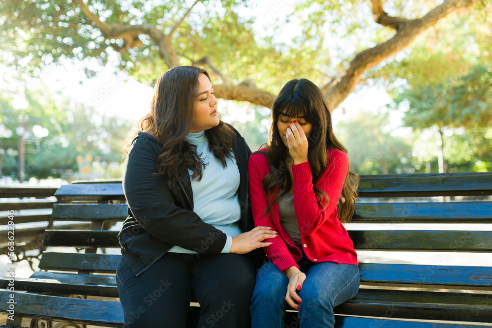 Sad latin woman crying while talking to her best friend Sad latin woman crying while talking to her best friend