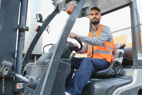 Waving forklift driver in the warehouse of a haulage company while driving forklift