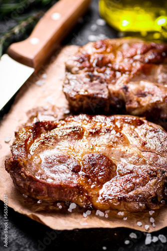 Grilled pork steak on paper on the table. 