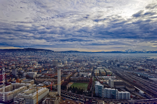 Aerial view of City of Zürich seen from industrial district with Lake Zürich and Swiss Alps in the background on a cloudy winter day. Photo taken December 20th, 2022, Zurich, Switzerland. © Michael Derrer Fuchs