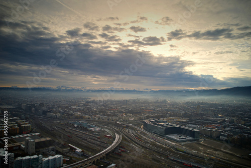Aerial view of City of Zürich seen from industrial district with Lake Zürich and Swiss Alps in the background on a cloudy winter day. Photo taken December 20th, 2022, Zurich, Switzerland.
