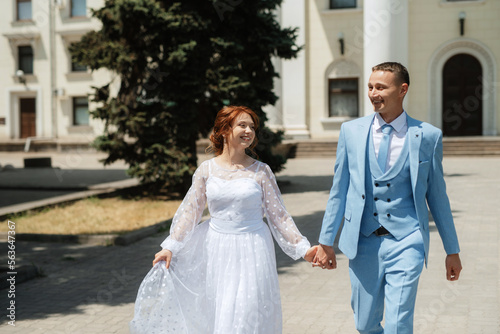 bride in a light wedding dress to the groom in a blue suit