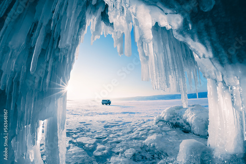 Ice cave with icicles on Baikal lake at sunset. Winter Baikal lake, Siberia, Russia