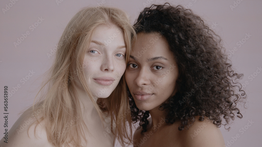 Candid portrait of two beautiful 20s females, African-American Black and Caucasian, posing against solid background, no make-up, studio shot, soft lighting Candid portrait of two beautiful 20s females, African-American Black and Caucasian, posing against solid background, no make-up, studio shot, soft lighting