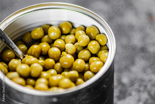 An open tin can with green peas. 