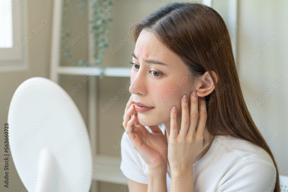 Dermatology, scratch asian young woman looking at mirror, expression worry and itch, itchy allergy or allergic sensitive reaction, red spot or rash on her face. Beauty care from skin problem treatment Dermatology, scratch asian young woman looking at mirror, expression worry and itch, itchy allergy or allergic sensitive reaction, red spot or rash on her face. Beauty care from skin problem treatment
