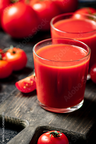Tomato juice in a glass on a cutting board. 