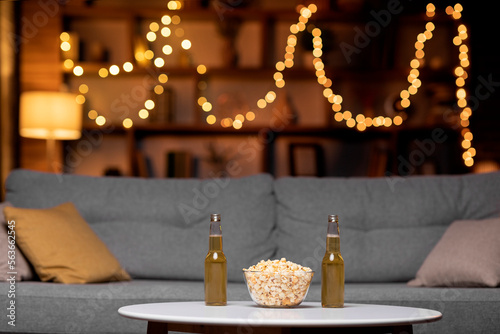 Canvas Print Glass bowl of popcorn and two bottles of beer