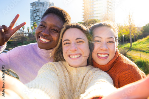 Three happy young women friends taking a selfie. International students having break during classes 