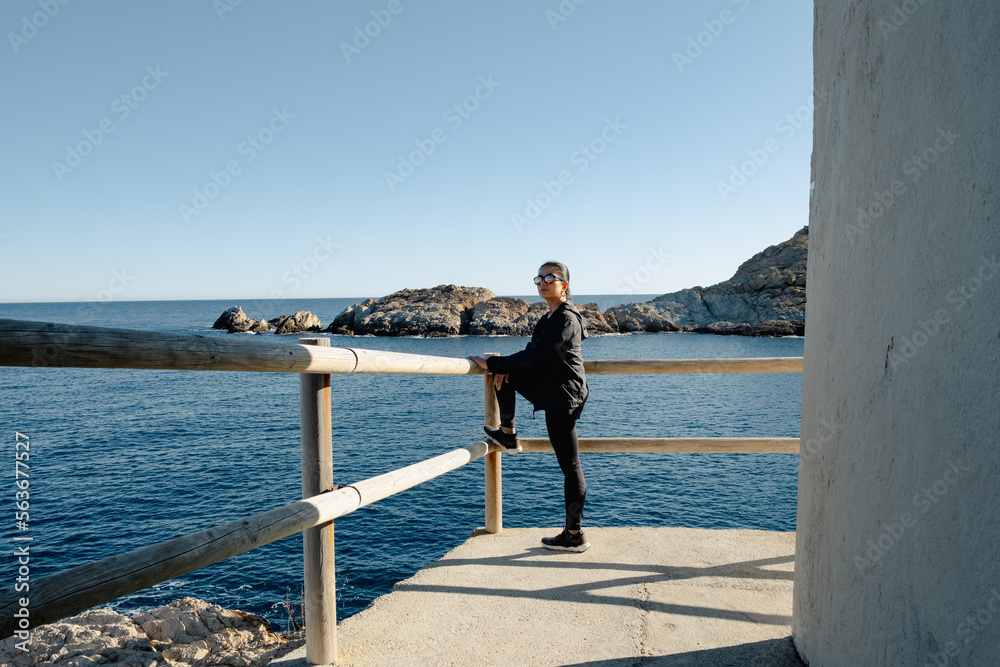 lonely woman contemplating the sea on a sunny day at the mediterranean coast  in Catalonia, Spain.