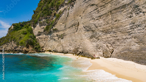 BALI INDONESIA - NOVEMBER 8, 2022: Aerial view to beautiful sandy beach (Diamond beach) with rocky mountains and clear water in Nusa Penida, Bali, Indonesia