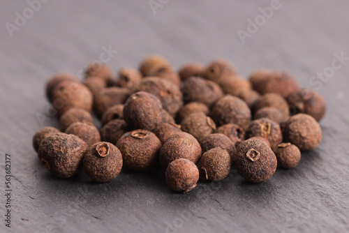 Black allspice in peas on a stone gray plate