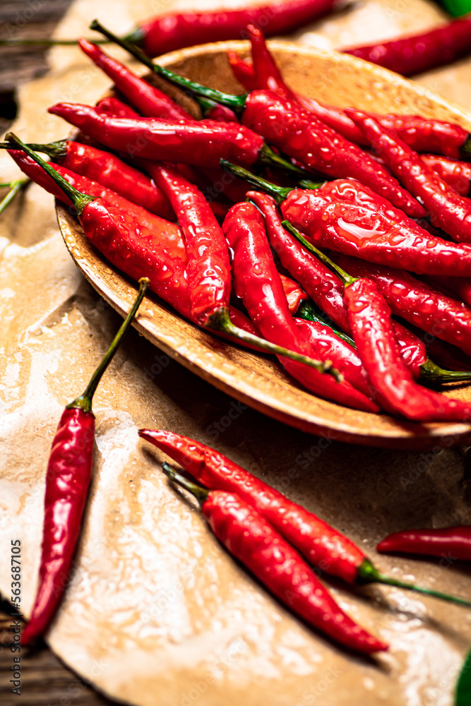 Hot chili peppers on a wooden plate. 