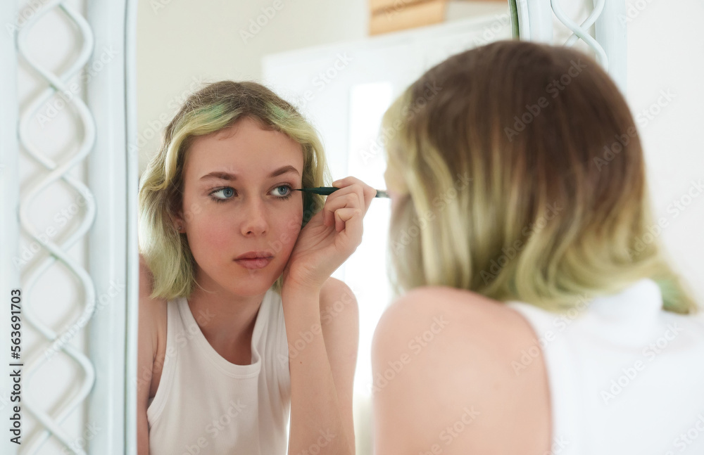 Teenage girl doing makeup with black eyeliner. Teenage girl doing makeup with black eyeliner.