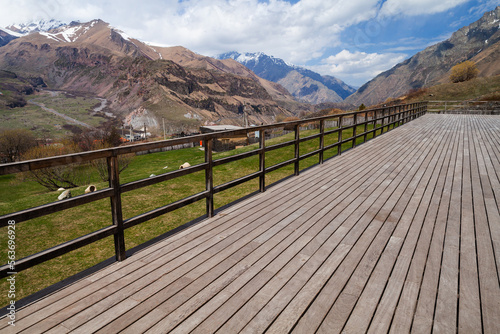 Empty wooden terrace with Stepantsminda landscape on a background