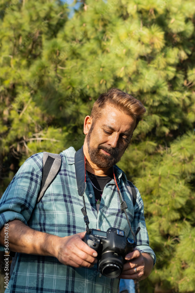 Nature photographer reviewing the day's photos in a natural setting.