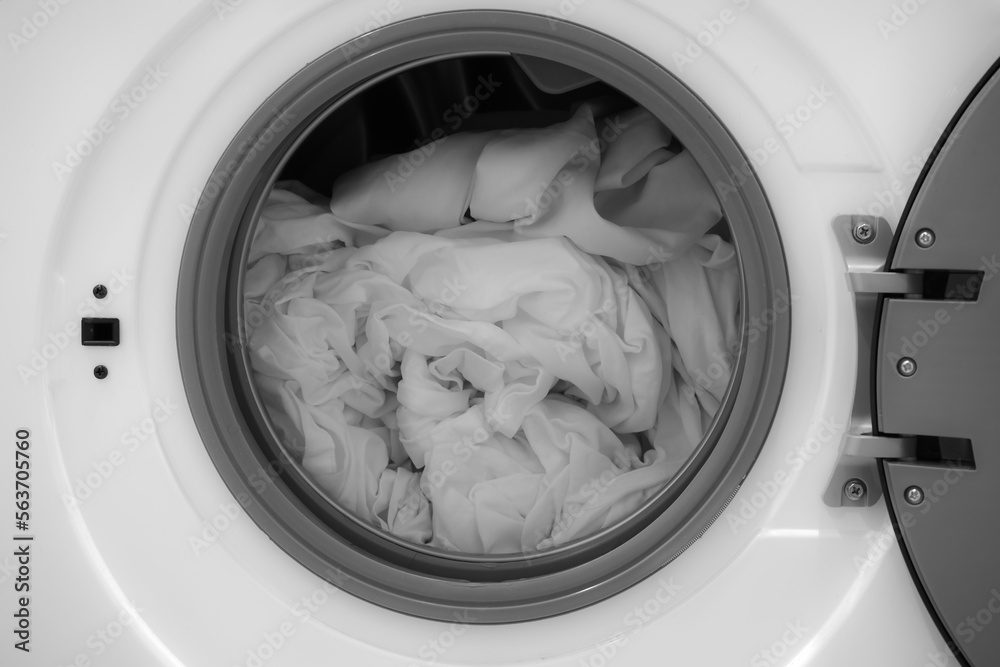 open drum of a washing machine washing white bed linen. Rotating drum in a washing machine tub with clothes. front washing machine and taking clean wet laundry. Unloading washing machine. Housekeeping open drum of a washing machine washing white bed linen. Rotating drum in a washing machine tub with clothes. front washing machine and taking clean wet laundry. Unloading washing machine. Housekeeping