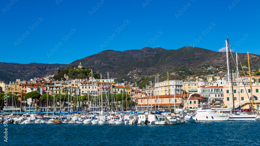 Sanremo, Italy, day view from the sea with boats and yachts to the old town of Sanremo (La Pigna) and Madonna della Costa Church on the hilltop, Liguria, Italy