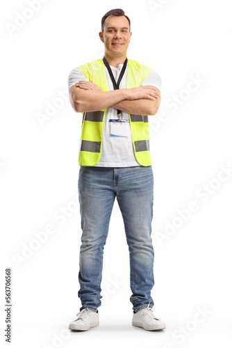 Full length portrait of a security guard in a safety vest standing with crossed arms