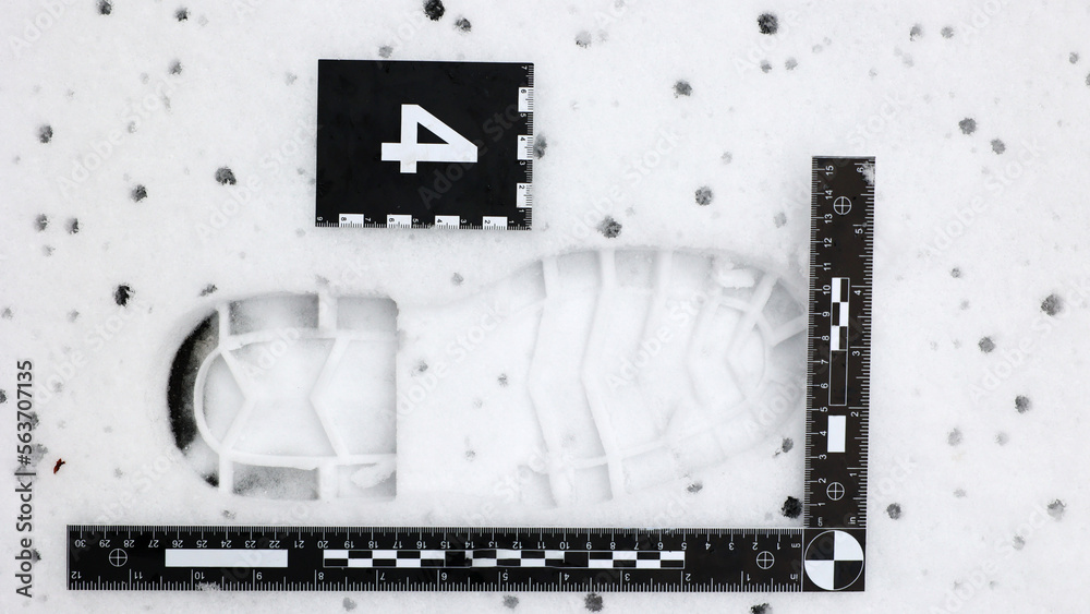 Ślad podeszwy buta odciśnięty w śniegu zabezpieczany na miejscu przestępstwa.  - obrazy, fototapety, plakaty 