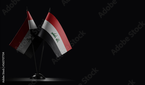 Small national flags of the Iraq on a black background