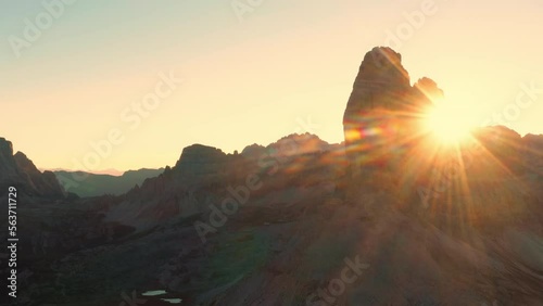 The rocky peaks of Tre Chime di Lavaredo in counter light. The edges of the high peaks lighted by the rays of the sun at dawn. photo