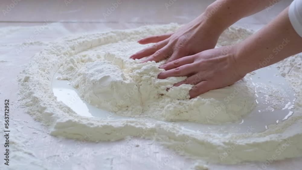 slow motion background for the text of cooking show art female hands stir the flour in form of heart they completely destroy pour it from above flour falls around the milk on light background slow motion background for the text of cooking show art female hands stir the flour in form of heart they completely destroy pour it from above flour falls around the milk on light background
