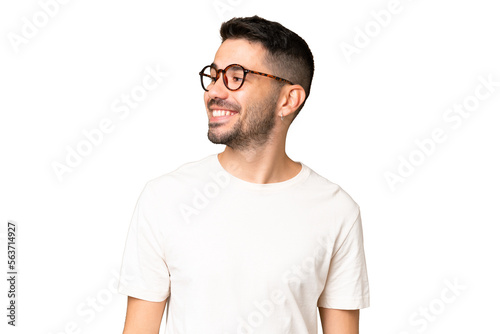 Young handsome caucasian man over isolated chroma key background looking to the side and smiling