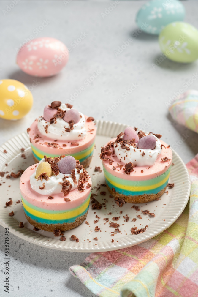 Easter mini cheesecakes with candy eggs and whipped cream.