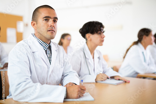 Portrait of doctors different age who writing exercises at lesson in university