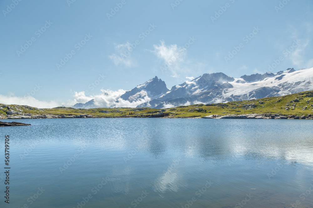 Lac Noir sur le plateau d'Emparis face au massif des Écrins et le sommet de la Meije en été Lac Noir sur le plateau d'Emparis face au massif des Écrins et le sommet de la Meije en été