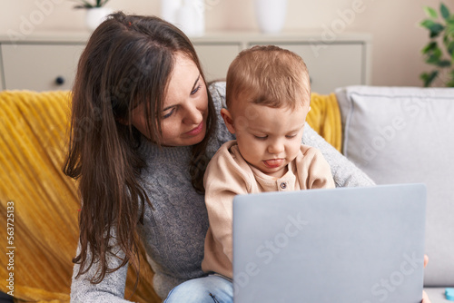 Mother and son using laptop sitting on sofa at home © Krakenimages.com