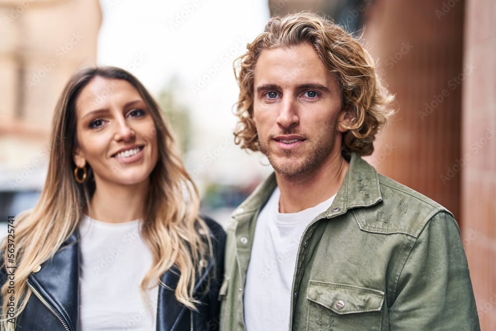 Fototapeta premium Man and woman couple smiling confident standing together at street