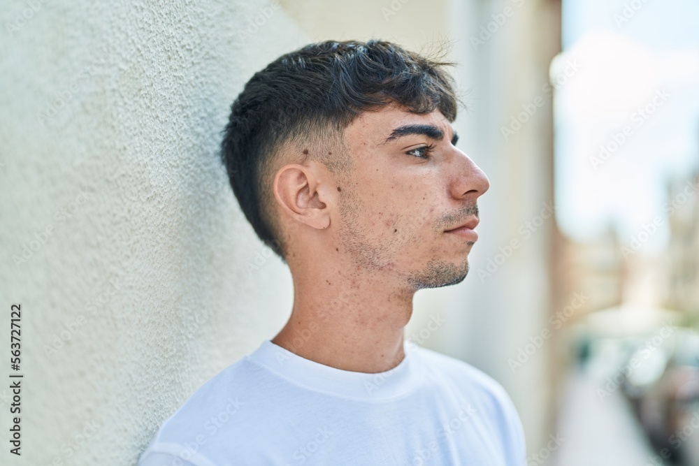 Young hispanic man looking to the side with serious expression at street Young hispanic man looking to the side with serious expression at street