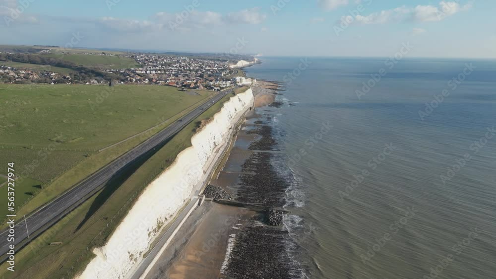 Aerial shot of a coastal town with white cliffs in England.
