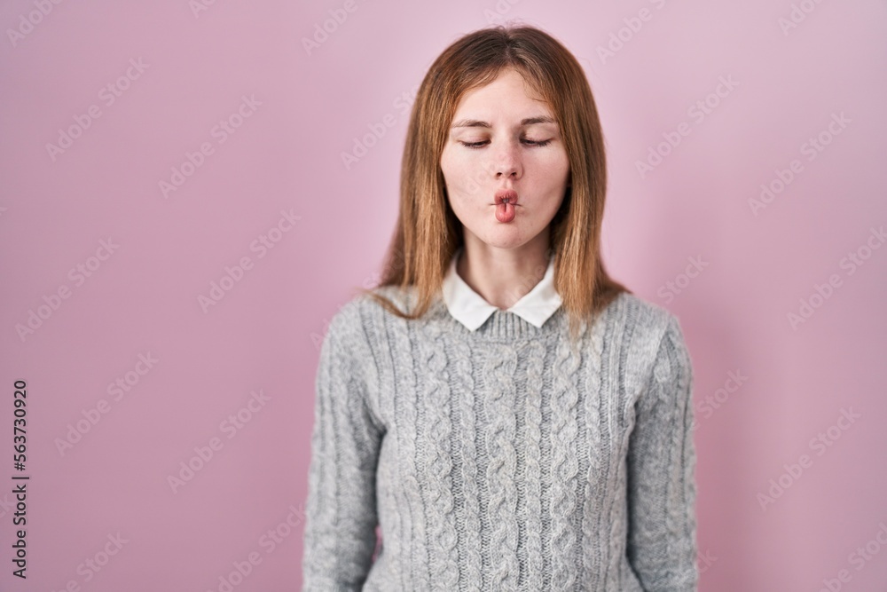 Beautiful woman standing over pink background making fish face with lips, crazy and comical gesture. funny expression. Beautiful woman standing over pink background making fish face with lips, crazy and comical gesture. funny expression.