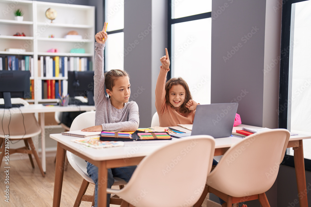 Two kids students using computer having online lesson at classroom Two kids students using computer having online lesson at classroom