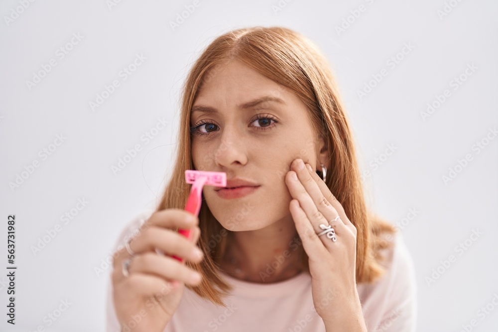 Young redhead woman using razor on moustache at bedroom Young redhead woman using razor on moustache at bedroom