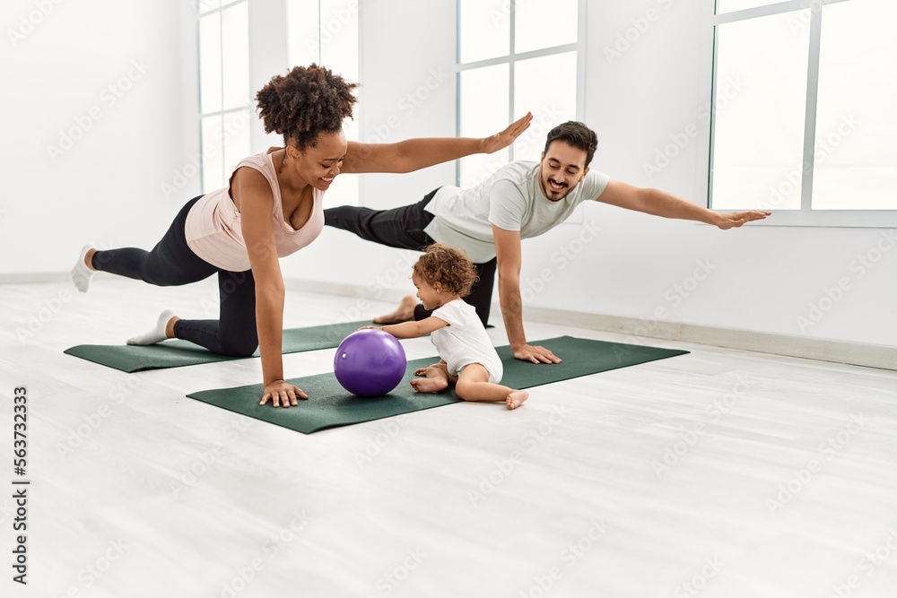 Couple and daughter smiling confident training yoga at sport center Couple and daughter smiling confident training yoga at sport center