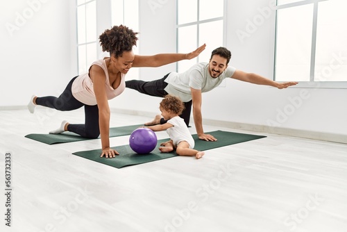 Couple and daughter smiling confident training yoga at sport center