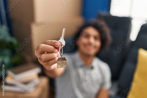 Wallpaper Mural Young hispanic man smiling confident holding key of new house at new home Torontodigital.ca