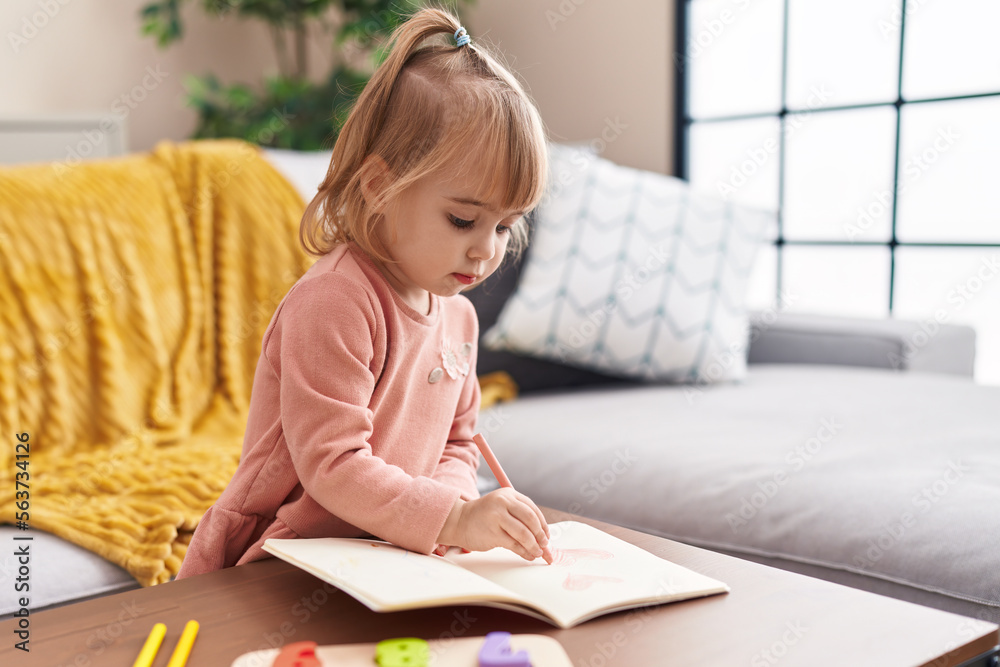 Adorable blonde girl drawing on notebook at home Adorable blonde girl drawing on notebook at home