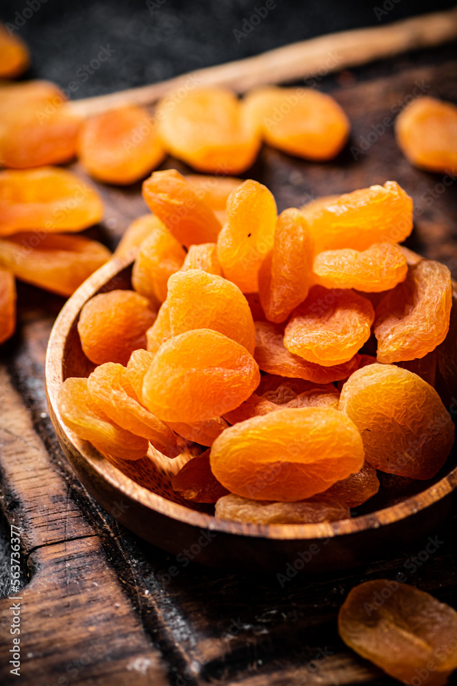 Dried apricots in a plate on a cutting board. Dried apricots in a plate on a cutting board.